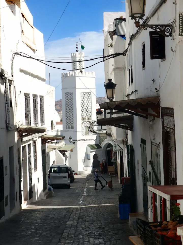 Une ruelle blanchie à la chaux de la médina de Tétouan, un minaret au bout